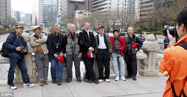 Leave, now: Foreign tourists pose for a picture in Seoul. North Korea urged foreigners in South Korea to evacuate
