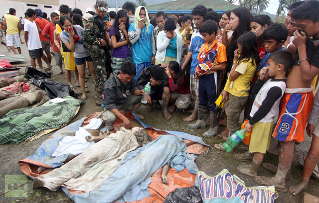 Relatives try to identify bodies in the aftermath of Typhoon Bopha in New Bataan, Compostela Valley in the southern Philippines on December 5, 2012. (AFP Photo/Karlos Manlupig)