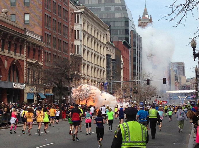 Runners continue to run towards the finish line of the Boston Marathon as an explosion erupts near the finish line of the race in this photo exclusively licensed to Reuters by photographer Dan Lampariello after he took the photo in Boston, Massachusetts, April 15, 2013 (Reuters / Dan Lampariello)