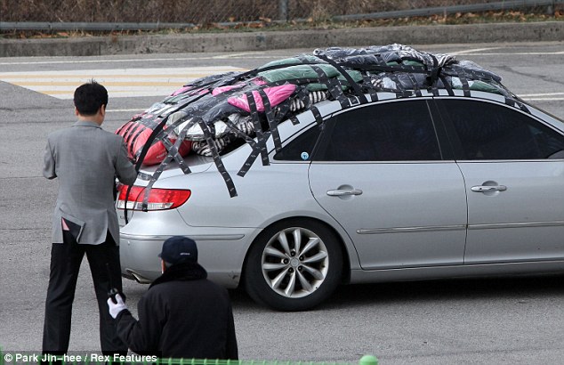 A South Korean vehicle - complete with padding taped to the roof - and workers return from the Kaesong industrial complex, a joint business zone operated by both Koreas