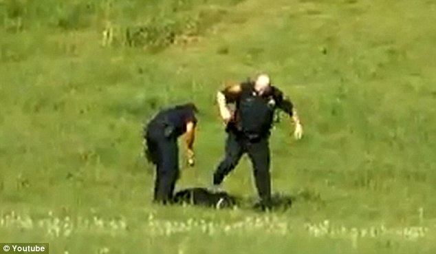 Attack: Two of the officers kick and stomp on the man