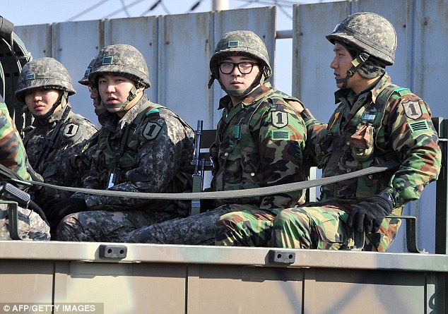On standby: South Korean soldiers ride a military truck on the road leading to North Korea as the co-ordinated military surveillance status was upgraded