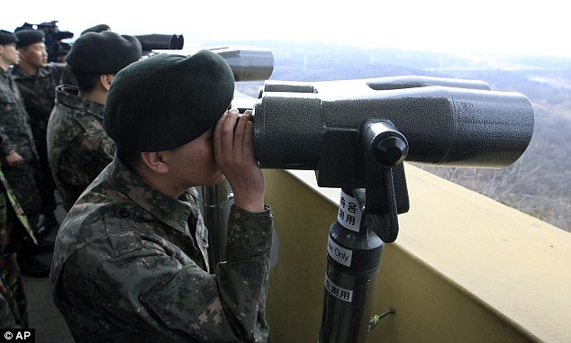 South Korean soldiers keep watch on North Korea through binoculars from an observation post near the border village of Panmunjom