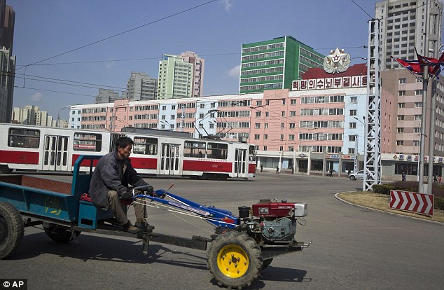 Business as usual: A North Korean man drives a small tractor in central Pyongyang