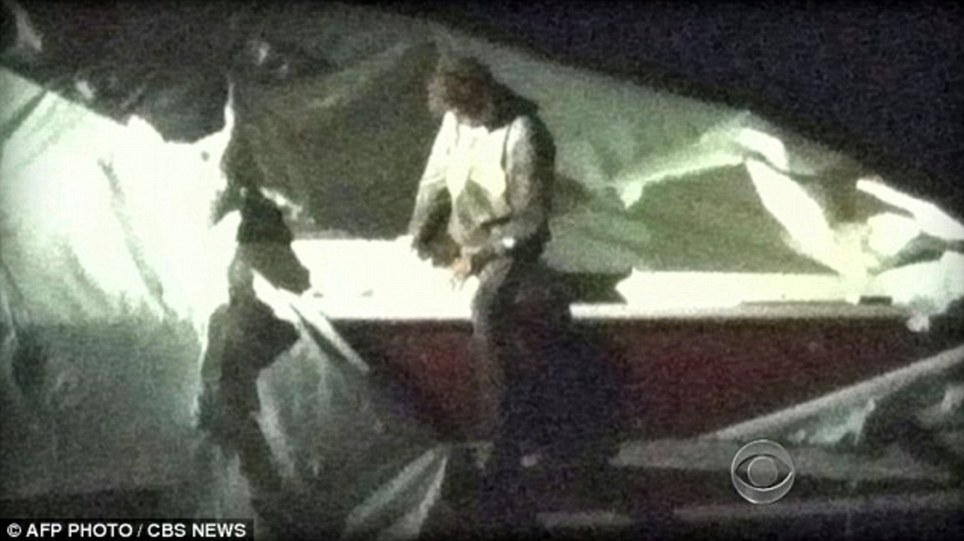 Hiding out: This is a surveillance video image of Tsarnaev getting out of the boat where he was pinned down on Friday night