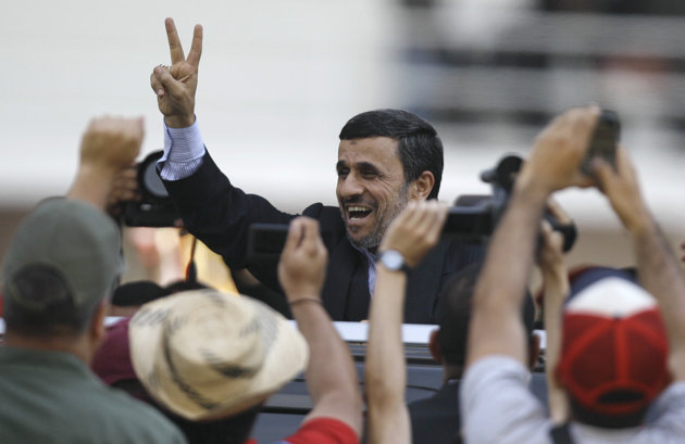 Iran's President Mahmoud Ahmadinejad makes a victory sign after attending the funeral ceremony for Venezuela's late President Hugo Chavez at the military academy in Caracas, Venezuela, Friday, March 8, 2013. Chavez died on March 5 after a nearly two-year bout with cancer. He was 58. (AP Photo/Fernando Llano)
