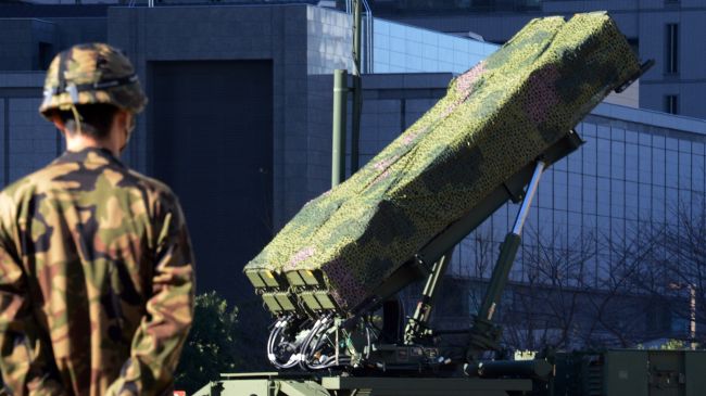 A soldier stands guard in front of Japan’s SDF set Patriot Advanced Capability-3 (PAC-3) missile launcher in Tokyo, December 6, 2012.
